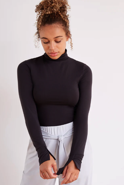 A lady wears a sustainable and ethical turtleneck from fair trade brand Aday.
